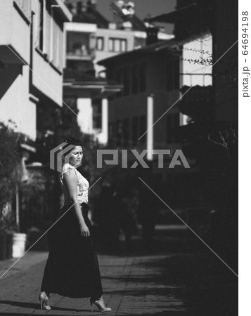 Woman standing on the street 64694198
