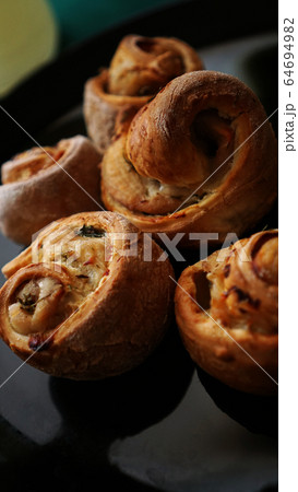 Chicken rolls from puff pastry on a black plate 64694982