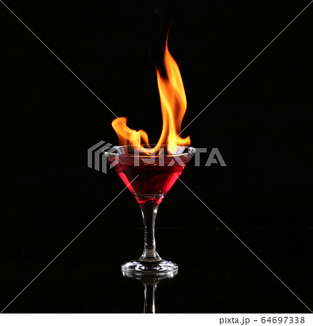 Burning alcoholic drinks with ice cubes, on black 64697338