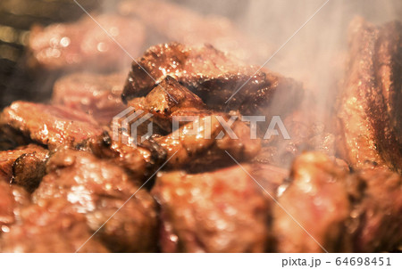 網の上で焼かれているお肉　炭火あみ焼きのお肉　あみ焼きで焼き上がったお肉 64698451