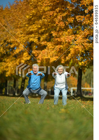 Portrait of fit senior couple exercising in park Portrait of fit senior couple exercising in park 64699935