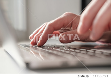 Fingers of female hands press the keys of an aluminum laptop ultrabook close-up with a shallow depth Fingers of female hands press the keys of an aluminum laptop ultrabook close-up with a shallow depth 64700293