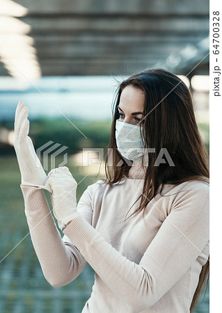 A girl with beautiful eyes wears a protective mask on her face in rubber gloves A girl with beautiful eyes wears a protective mask on her face in rubber gloves 64700328