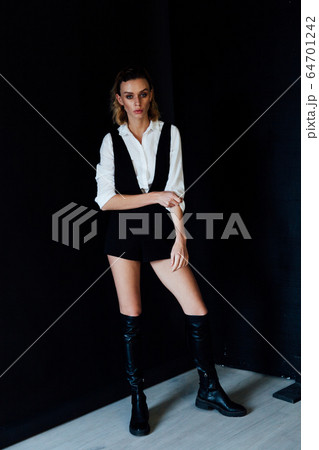 Portrait of a beautiful young fashionable blonde woman in a shirt and black shorts 64701242