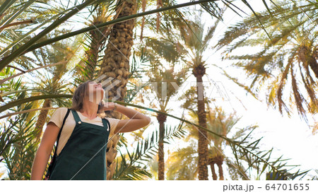 Beautiful girl against the background of palm trees in a park near the city of Al Ain. UAE. Beautiful girl against the background of palm trees in a park near the city of Al Ain. UAE. 64701655