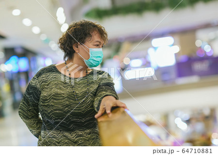 Old asian woman in a mask for COVID-19, for protection against the crown virus. Asian senior woman with protective mask because dirty air smog, PM2.5. Coronavirus old woman walking with surgical mask 64710881