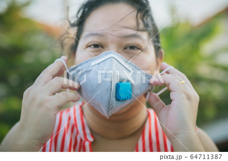Asian woman hold mask in hand for COVID-19, for protection against the crown virus.  64711387