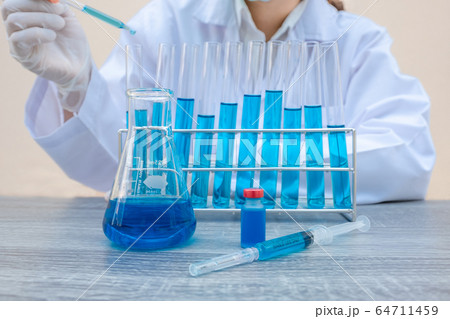 The scientist is experimenting with the blue serum The scientist is experimenting with the blue serum 64711459