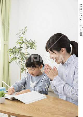 自宅で子供に勉強を教える母親の写真素材 自宅で子供に勉強を教える母親の写真素材