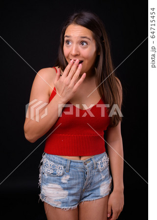 Young multi ethnic beautiful woman against black background 64715454