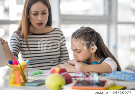 Mom doing lessons with her daughter at home. 64716074
