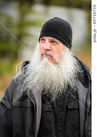 Face of mature bearded hipster man with hat thinking 64716739