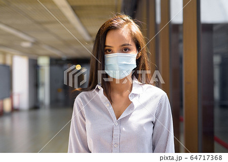 Young Asian tourist woman with mask for protection from corona virus outbreak at the airport Young Asian tourist woman with mask for protection from corona virus outbreak at the airport 64717368