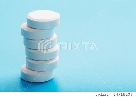 Round medicinal pills tower on a blue background, 64719209