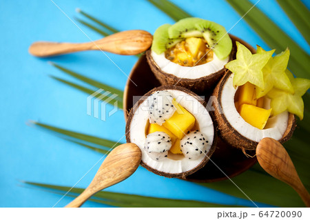 mix of exotic fruits in coconut shells with spoons mix of exotic fruits in coconut shells with spoons 64720090
