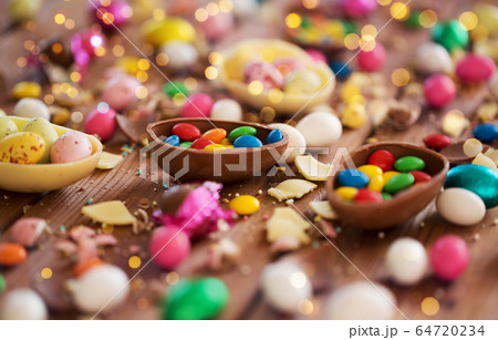 chocolate eggs and candy drops on wooden table chocolate eggs and candy drops on wooden table 64720234