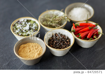 bowls with different spices on slate stone table 64720571