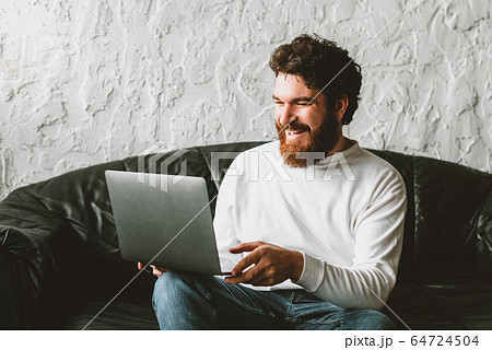 charming young man working at home in laptop 64724504