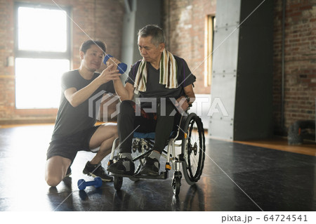 トレーナーと一緒にリハビリをするシニアの男性 64724541