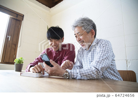 若者からスマートフォンを教わるシニア 64724656
