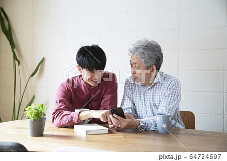 若者からスマートフォンを教わるシニア 64724697