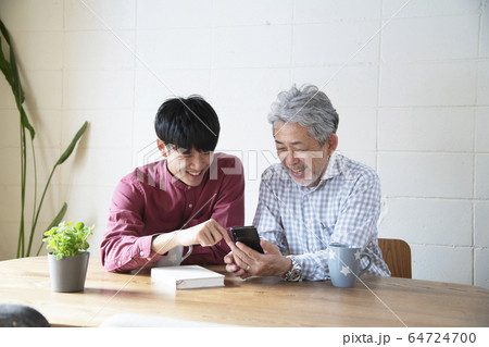 若者からスマートフォンを教わるシニア 64724700