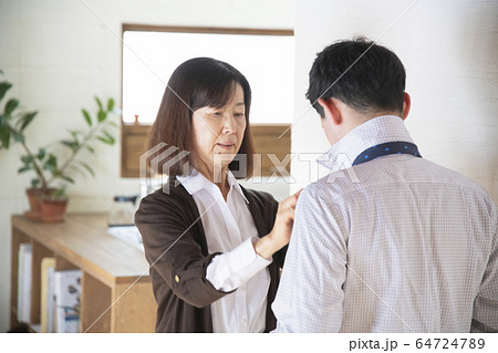 祖母にネクタイを結んでもらう孫 64724789