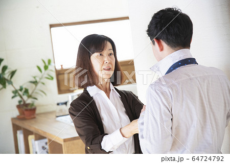 祖母にネクタイを結んでもらう孫 64724792