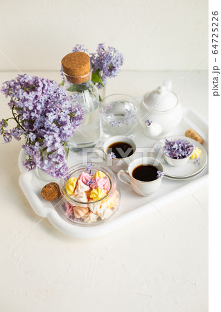 Breakfast with black tea or coffee and sweet meringue kisses on the white table. 64725226