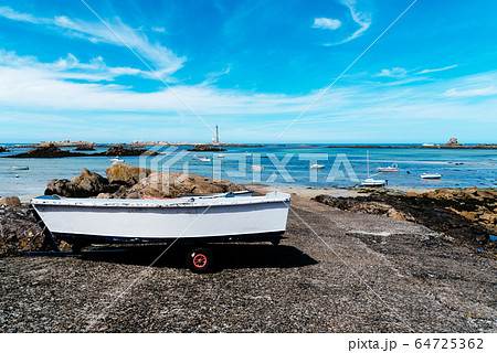 Boat out of water in the pier against bay with lighthouse a sunny day of summer Boat out of water in the pier against bay with lighthouse a sunny day of summer 64725362