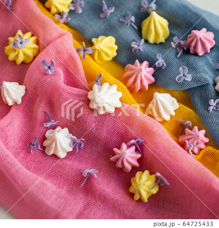 Some colorful meringue kisses are on the gauze. Top view. 64725433