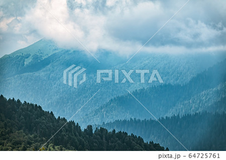 High mountains with green slopes in dense fog. High mountains with green slopes in dense fog. 64725761