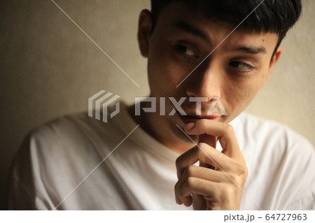 唇に触れる男性 64727963