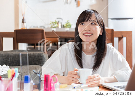 朝自宅でコーヒーを飲む若い女性 64728508