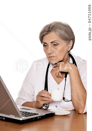 Portrait of confident female doctor sitting at table isolated  64731066