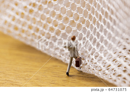 網の目を抜けようとするビジネスマン 網の目を抜けようとするビジネスマン 64731075