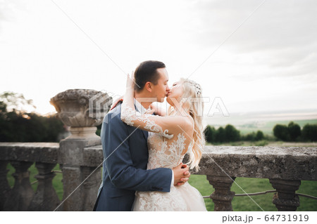 Romantic wedding moment, couple of newlyweds smiling portrait, bride and groom hugging 64731919