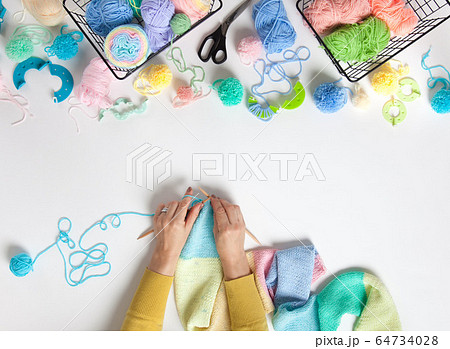 Women crochet and knitting from colored yarn. Top view. 64734028