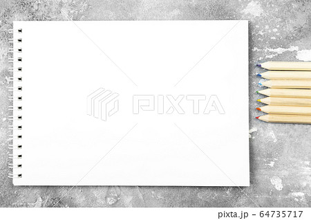 White notebook and colored pencil on gray 64735717