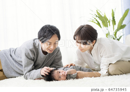 生後三ヶ月の男の子と触れ合う夫婦の写真素材