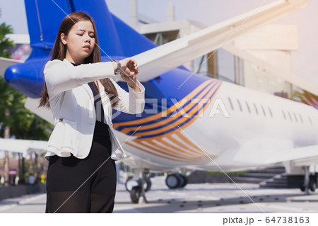 Beautiful Asian business woman watching watch in 64738163