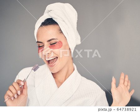 High-spirited young woman with her eyes closed 64738921