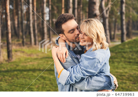 Happy woman and her bearded boyfriend standing outdoors Happy woman and her bearded boyfriend standing outdoors 64739963