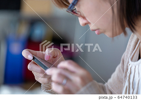 携帯電話を操作する女性 携帯電話を操作する女性 64740133