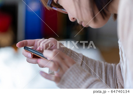 携帯電話を操作する女性 携帯電話を操作する女性 64740134