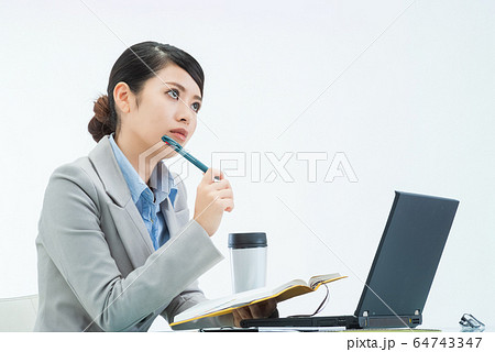 デスクワーク中に手帳を手に考え事をする若い女性 02 デスクワーク中に手帳を手に考え事をする若い女性 02 64743347