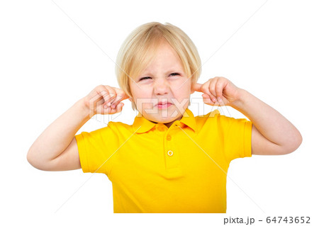 Annoyed boy covers his ears with fingers 64743652
