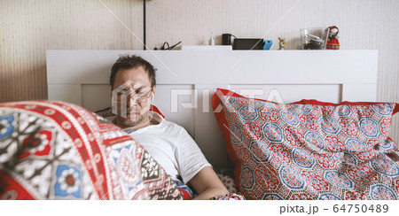 Man work and look at phone in bed. Man work and look at phone in bed. 64750489