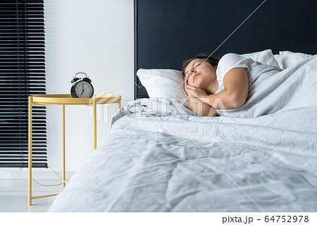 The girl sleeps next to the alarm clock. Time to The girl sleeps next to the alarm clock. Time to 64752978
