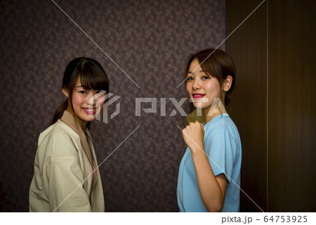 エステ　ガッツポーズをするエステティシャンと若い女性 64753925